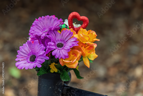 Bilde på lerret Artificial flowers tribute attached to memorial bench outdoors