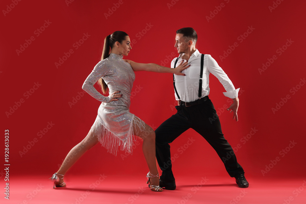 Naklejka premium Couple of professional dancers on red background