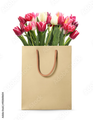 Colorful tulips in paper bag on white background. Romantic gift