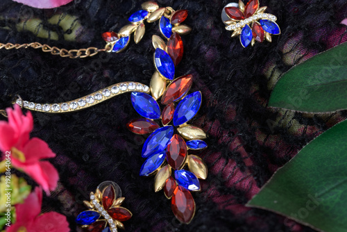 Colorful gemstone necklace and earrings on fabric.