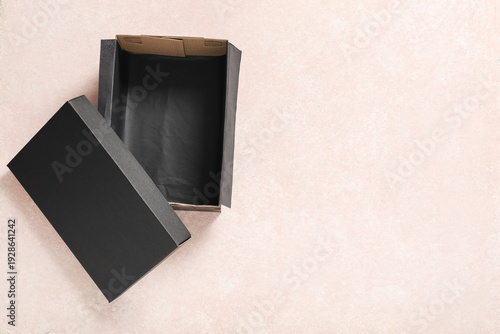 Black open shoebox on pink ...
