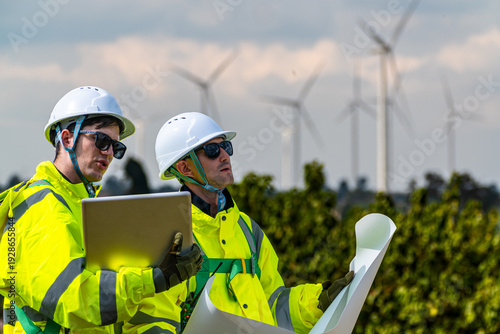 Foto Field project managers synchronizing operational schedules via smartwatch at industrial construction site