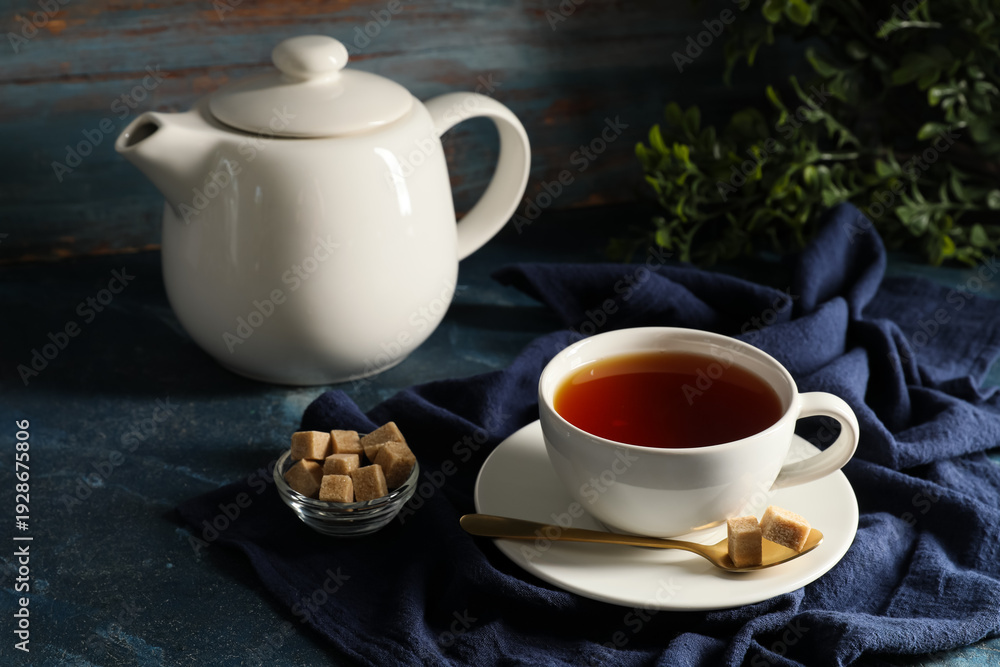 Fototapeta premium Composition with teapot and cup of black tea on blue grunge background, closeup