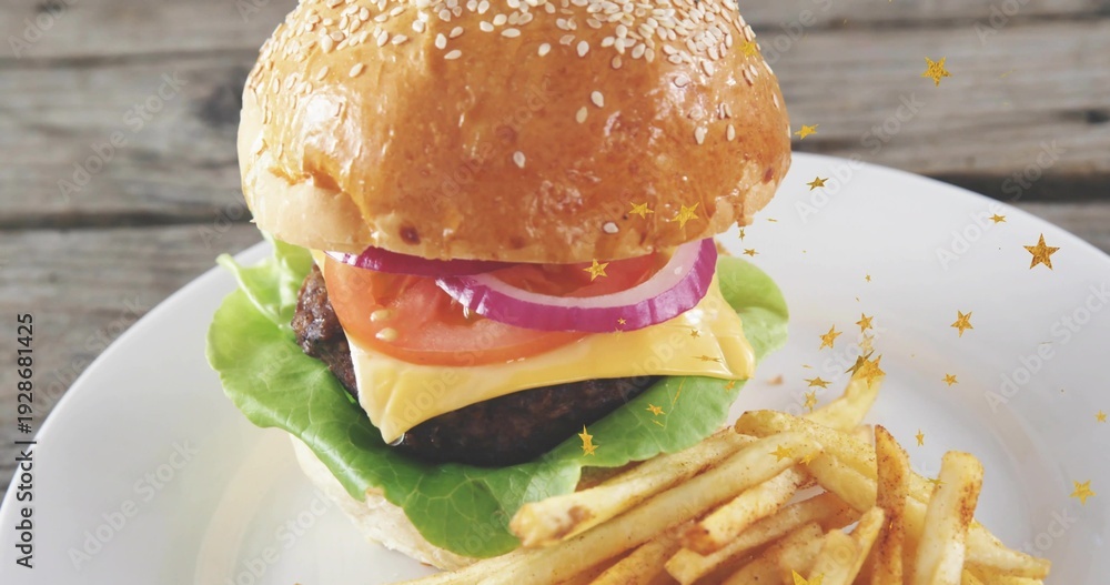 Fototapeta premium Displaying stacked burger with sesame bun, cheddar and fries on ceramic plate, gold stars