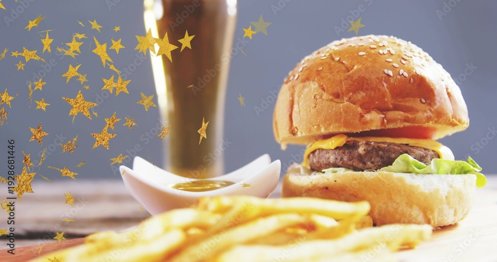 Obraz premium Showcasing sesame bun cheeseburger sitting on studio board with fries, sauce, confetti, copy space