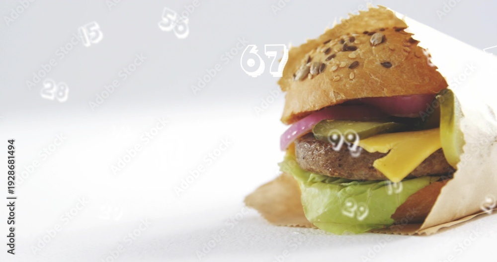 Fototapeta premium Displaying wrapped burger sitting on studio tabletop with seeded bun, numeric overlays, copy space