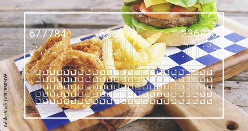 Displaying beef burger, onion rings and fries on cutting board on rustic table with UI overlay