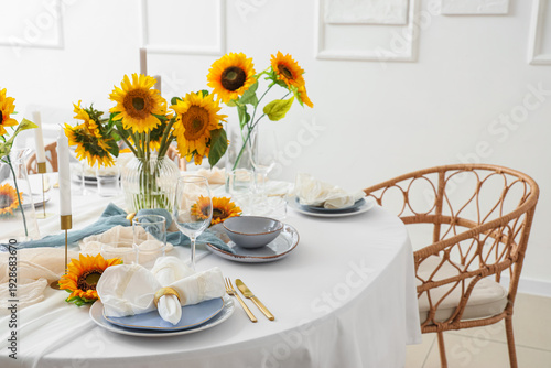 Elegant table serving with plates, folded napkin and beautiful sunflowers, closeup