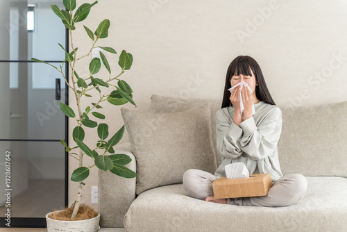 Young Asian woman blowing her nose with hay fever, rhinitis (cedar pollen, cypress pollen, allergic rhinitis)
