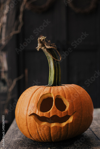 halloween pumpkin on a wooden table carved for a halloween party in October.