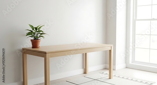 Minimalist wooden table with a potted plant placed in a bright room with white walls and large window enhancing natural light