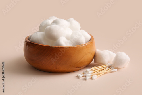Tablou pe pânză Wooden bowl with cotton balls and swabs on beige background