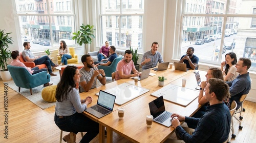 Diverse team collaborating in a modern bright open-plan office discussing ideas around a large conference table with laptops and coffee cups