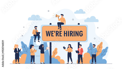 Team of workers collaborating around a large orange sign that says we are hiring for business recruitment goals.