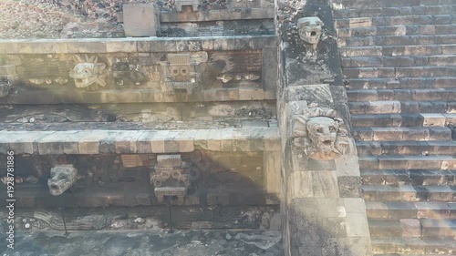Close-up of carved stone serpent heads and ancient reliefs on Teotihuacan’s Temple of Quetzalcoatl, with sun flare and weathered textures for history documentary b-roll.