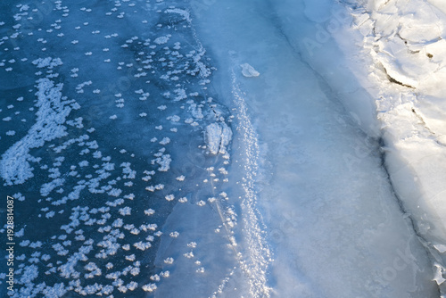 Ice and frost flowers on a frozen river in winter