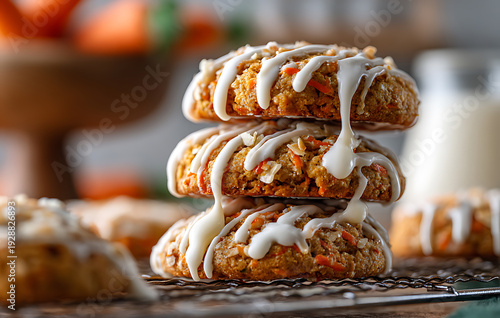 Stack Of Three Carrot Cake Cookies Drizzled With White Icing Topped With Nuts On A Wire Rack Soft Focus Background