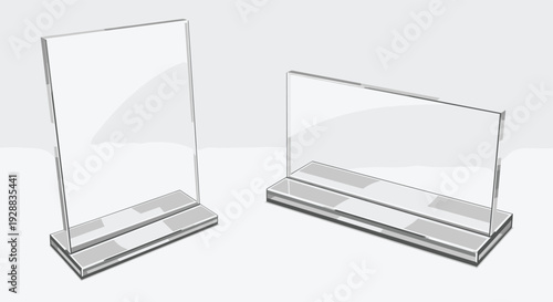 Pair of transparent acrylic sign holders in vertical and horizontal orientations sitting on a plain gray surface for display.