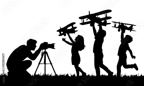 Silhouette of children playing with toy airplanes while adult photographs them