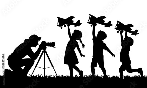 Silhouette of children playing with toy airplanes while adult photographs them