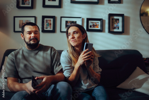 Fotografi Woman Hiding her Phone while Suspicious Partner Looks Away