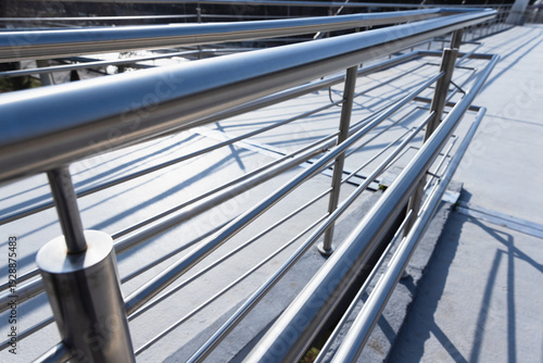 Slika na platnu Perspective view of a polished stainless steel railing and handrail on a modern