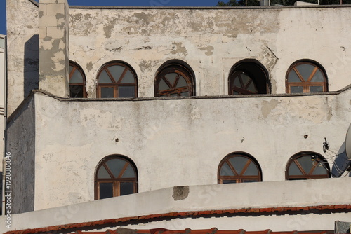 Wallpaper Mural Old building facade with arched wooden windows under clear sky Torontodigital.ca