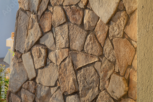 Wallpaper Mural Stone wall with irregular shaped rocks and plaster edge under blue sky Torontodigital.ca