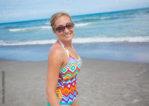 Beautiful middle-aged woman playing on a beautiful beach. Candid beach vacation lifestyle photo