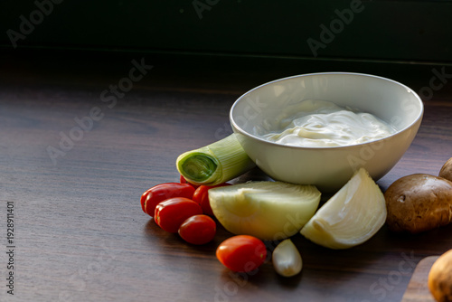 Creamy sauce with fresh vegetables on wooden table