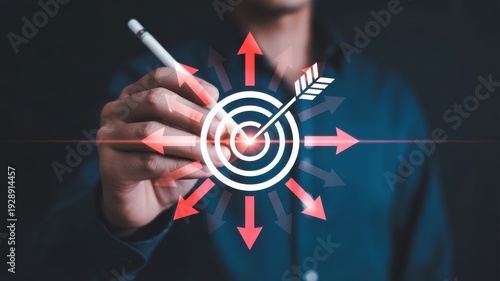 Hand of businessman pointing pen at target icon with radiating red arrows, symbolizing successful strategy and business achievement