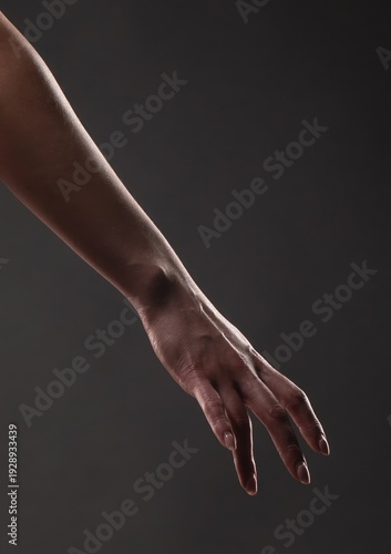 Canvastavla Arm and hand reaching down against a dark gray background