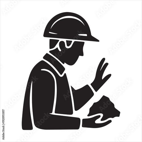Silhouette of a worker in hard hat holding rock sample geology
