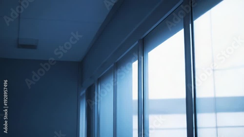 Modern architecture featuring a glass facade with window reflections creating an abstract pattern and blue tint, suitable for corporate and minimalist themes