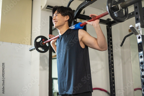 バーベルを担ぐ男性