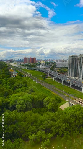 Close view  Moscow City in Russi. The view of a city with many buildings and roads. City view of roads and buildings near green trees under a cloudy sky during the day in summer.