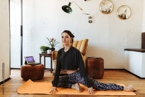 Young woman practicing yoga at home