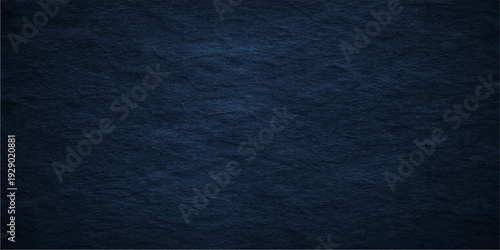 A dark blue grunge background features a rough denim fabric texture with a weathered cotton textile pattern on a dark indigo paper surface