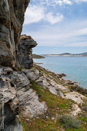 Rocky, hilly and lush landscape at the Paros Park and the Aegean Sea on Paros island in Greece on a sunny day.