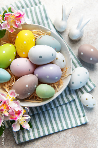 Pastel easter eggs in a bowl with spring flowers