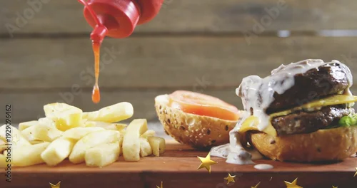 Obraz Displaying stacked beef burger melting cheese and creamy sauce on wood board with fries, copy space