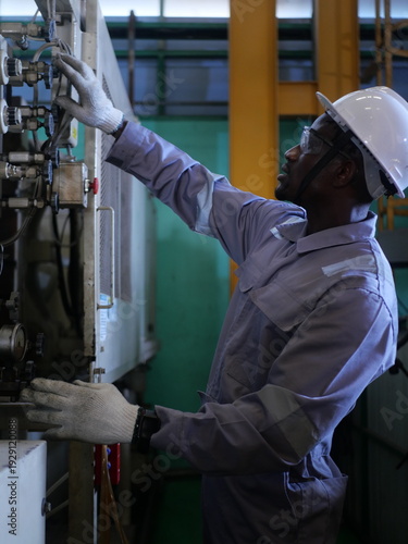 Automotive mechanic wearing PPE working in manufacturing line
