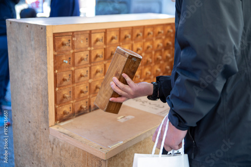神社でおみくじを引く人