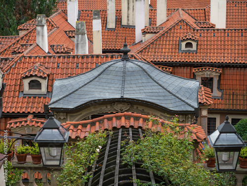 Photography Close Up View Of A Dark Octagonal Roof Structure Surrounded By Red Tile Rooftops