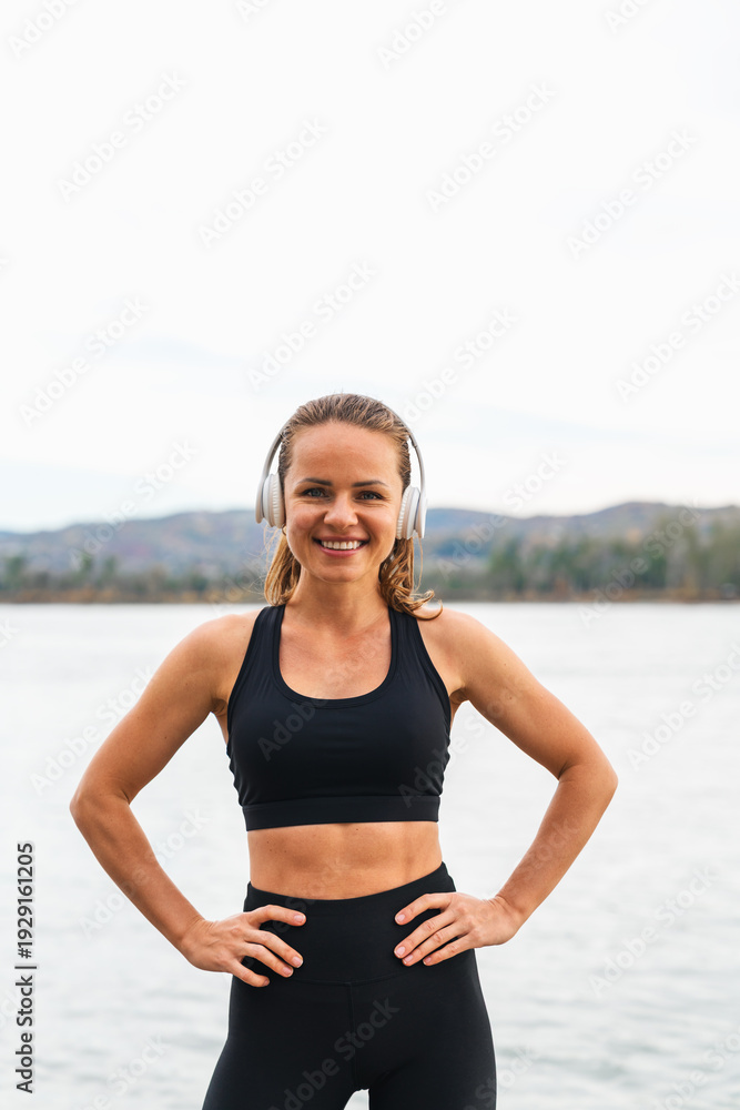 Fototapeta premium Fitness woman relaxing outdoors near river after workout