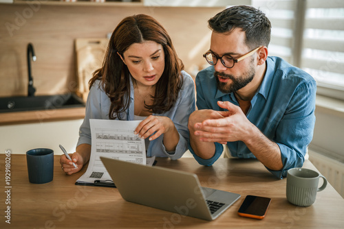 Canvas Print Couple discussing budget and finances at home kitchen desk