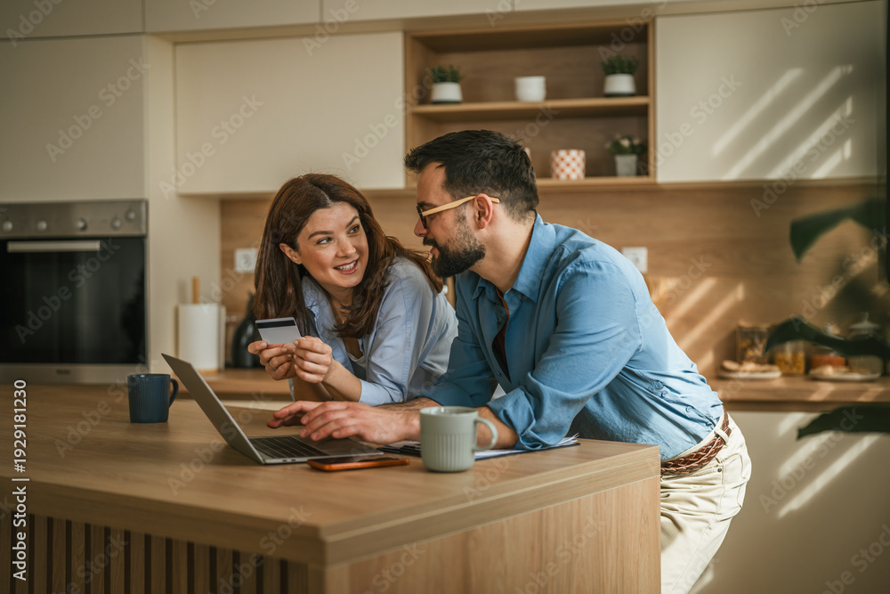 Obraz premium Couple managing home finances shopping online with credit card