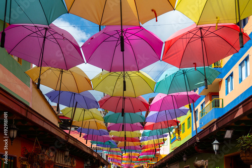 July 17, 2023: Artistic Umbrella Canopy Floating Above Traditional Colorful Street In Guatape, Antioquia, Colombia