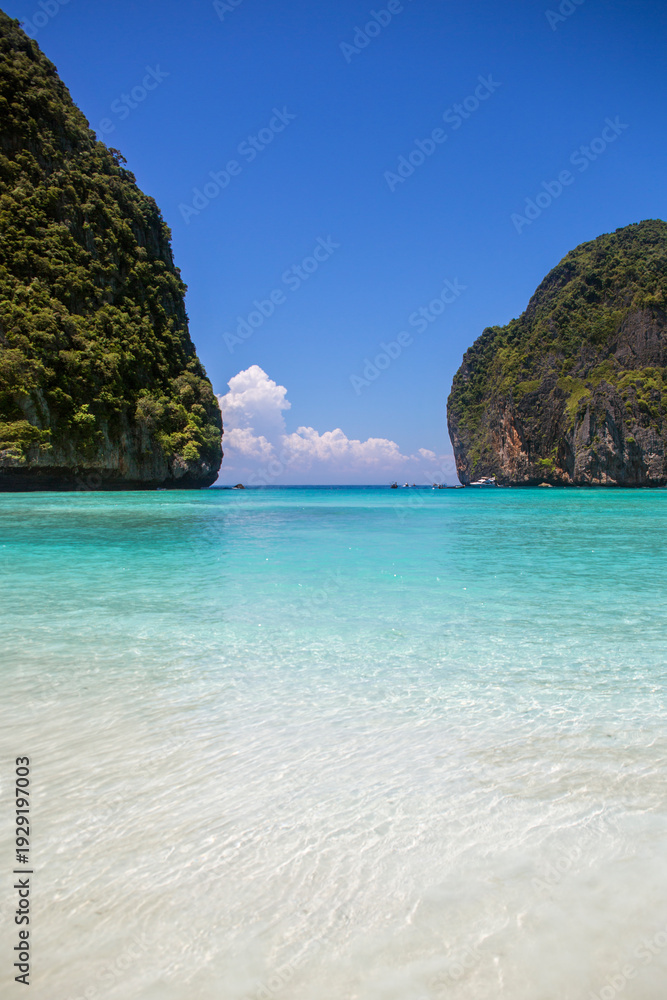 Fototapeta premium Panorama of Maya Bay on Koh Phi Phi Leh, Thailand. It's a beautiful, exotic shore with a crystal-clear turquoise waters. A pristine and tropical gulf enclosed by towering limestone karst cliffs.