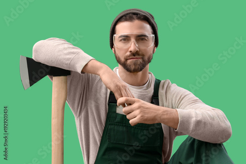 Male worker with ax on gree...